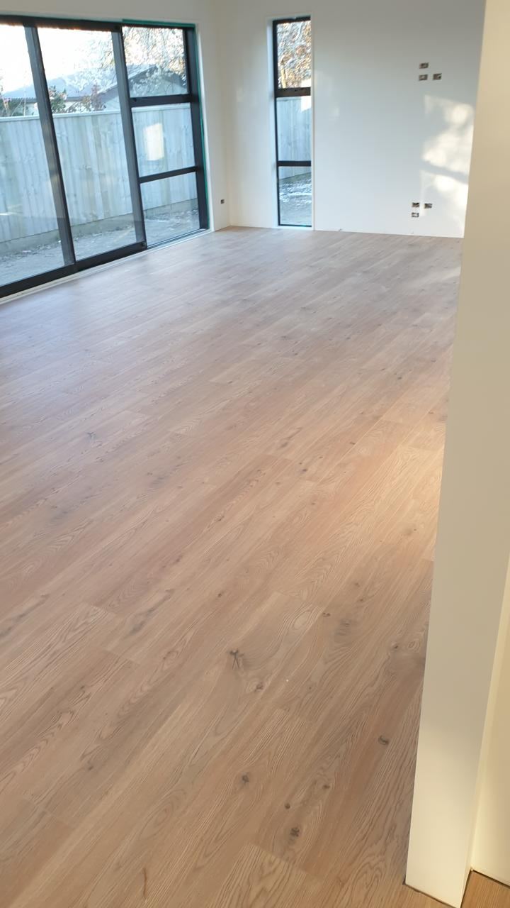 After: finished light oak flooring running through an open living space