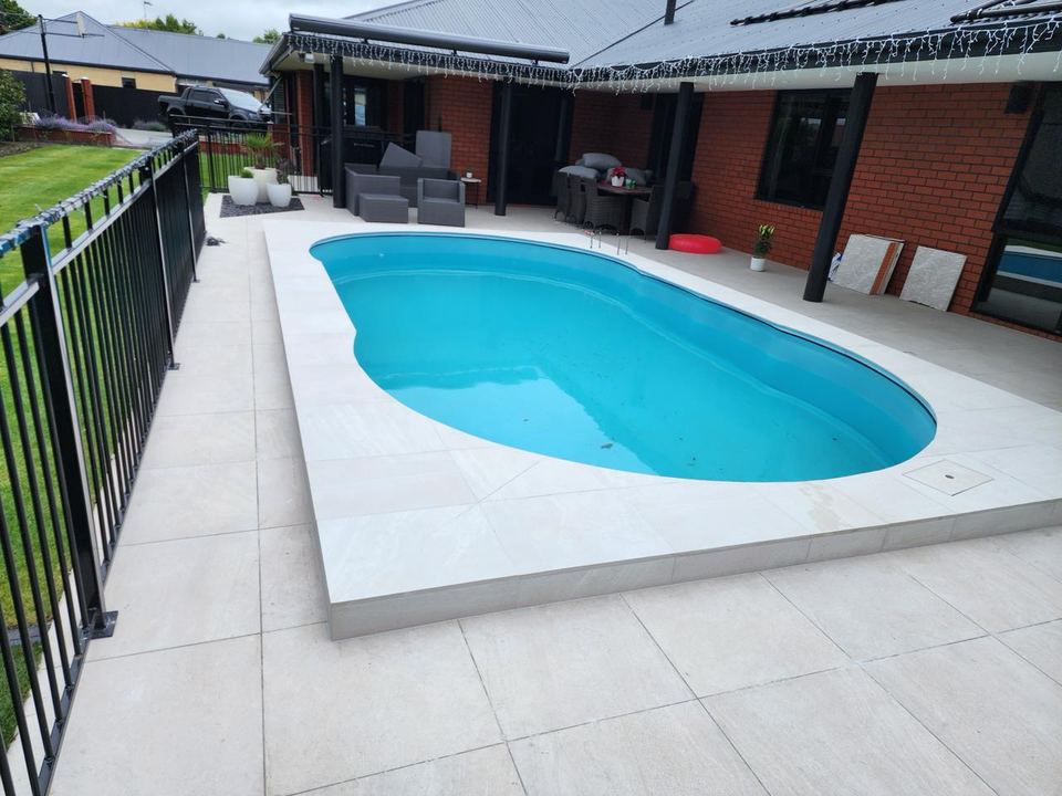 After: large-format porcelain tiles laid around the pool surround